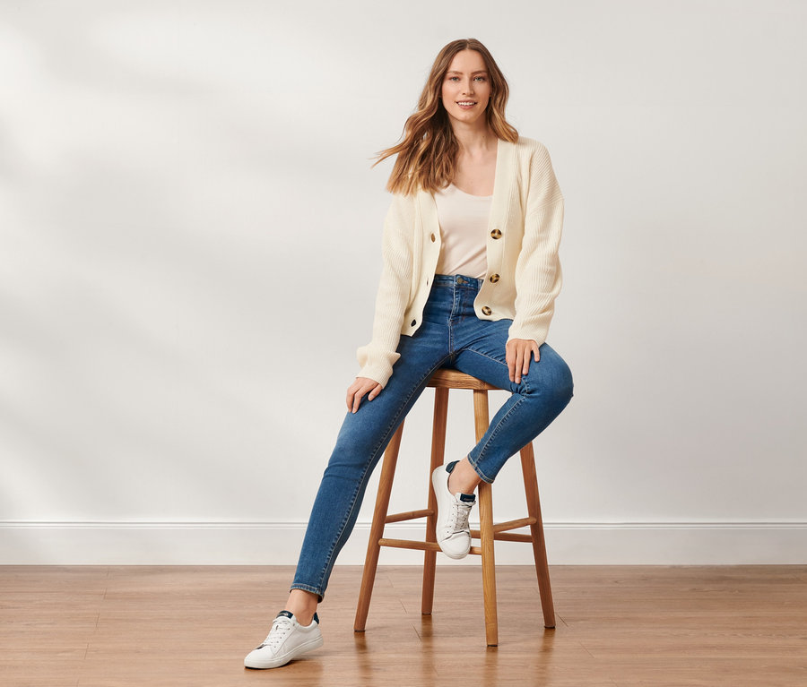Frau sitzt auf einem Hocker und trägt eine Skinny-Denim »Fit Hanna«.