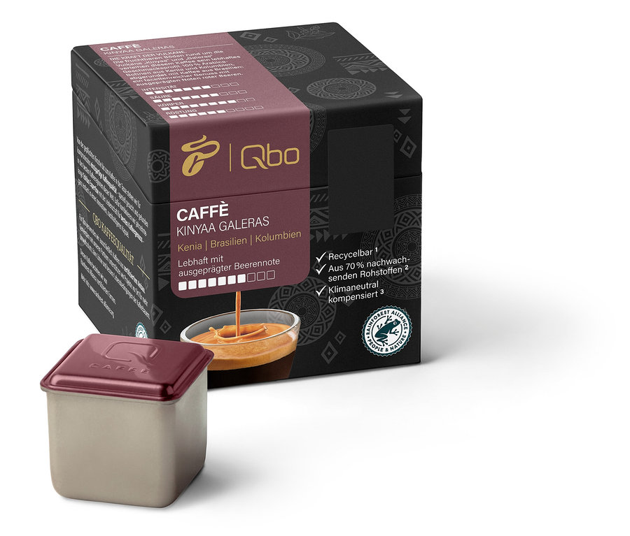 Eine Packung Qbo Caffè KINYAA GALERAS und eine Kapsel. Die Packung ist schwarz mit Schrift und Grafik. Die Kapsel ist silberfarben mit braunem Deckel.