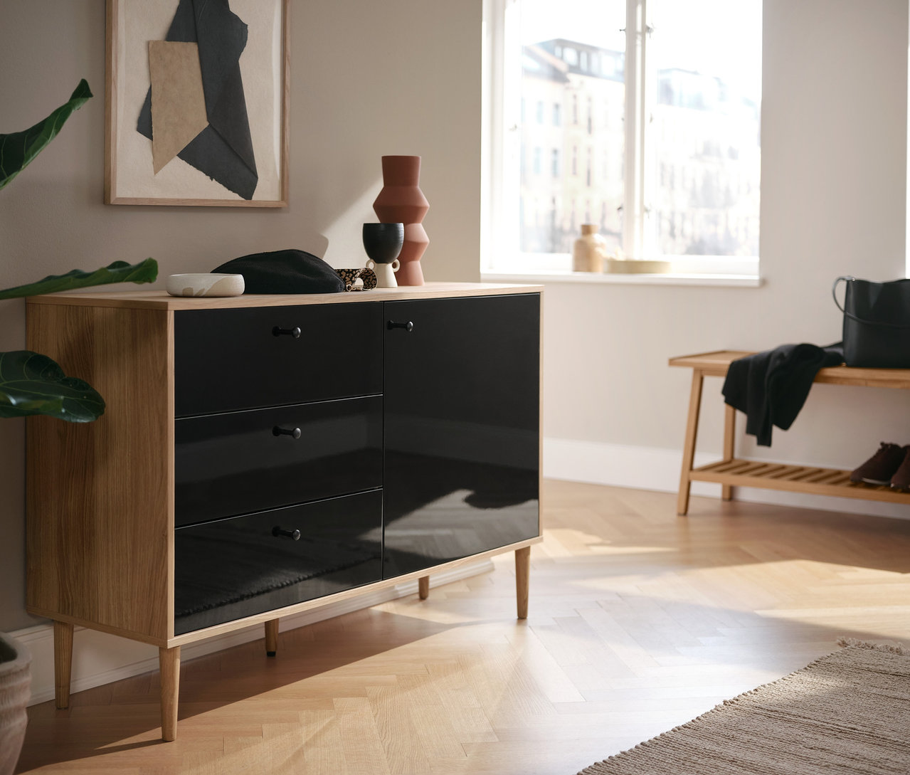 Anthrazitfarbene Kommode »Bekeson« und eine Sitzbank mit Ablage stehen im Raum.