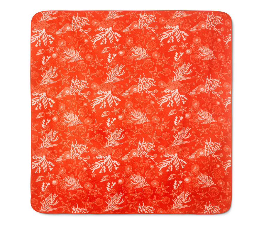 Detailaufnahme einer XL-Picknickdecke mit orangefarbenem Hintergrund und weißem Aufdruck von Seesternen, Muscheln und Korallen.
