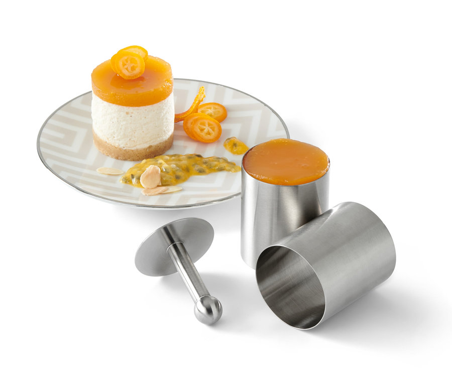 Dessert auf Teller neben 4 Vorspeisen- und Dessertringen.