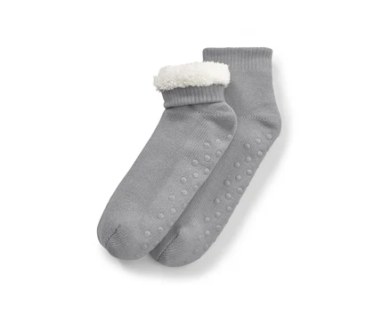 Graue Hausschuh-Socken mit weißem Fell oben und rutschfester Sohle.