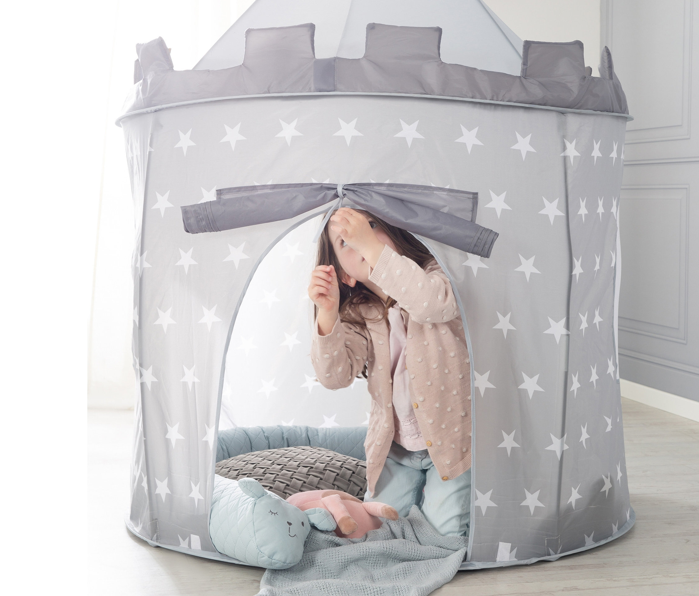 Mädchen spielt im grauen roba Spielzelt »Ritterburg« mit weißen Sternen.