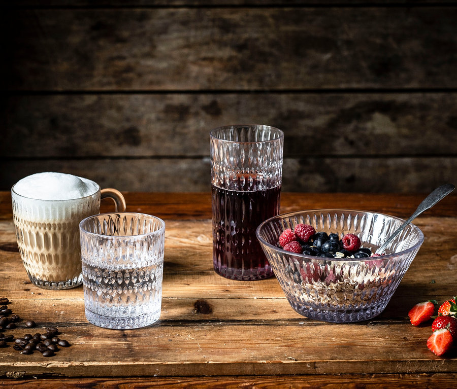 Auf einem Holztisch stehen ein Glas Kaffee, ein Glas Wasser, ein Glas mit einem roten Getränk und eine Schüssel mit Müsli und Früchten. Zu sehen sind 6 Nachtmann Schalen »Ethno«, ca. 16 cm.