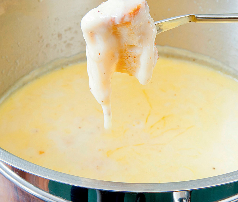 Brotstück wird in CASO Induktions-Fondue getunkt.