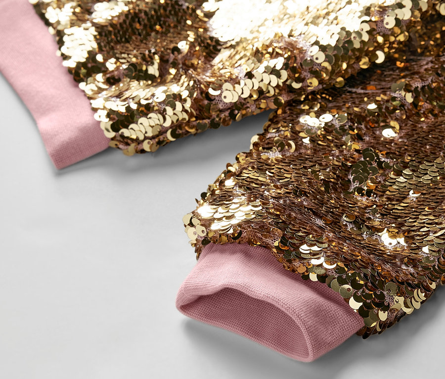 Detailansicht einer Kinder-Paillettenjacke mit hellrosa Bündchen.
