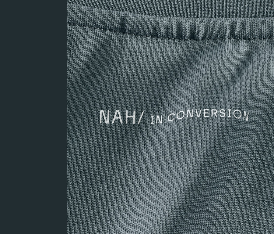 Detailaufnahme eines grauen NAH/STUDIO Heavy Weight Shirts aus nachhaltiger Baumwolle mit dem Aufdruck NAH/IN CONVERSION.