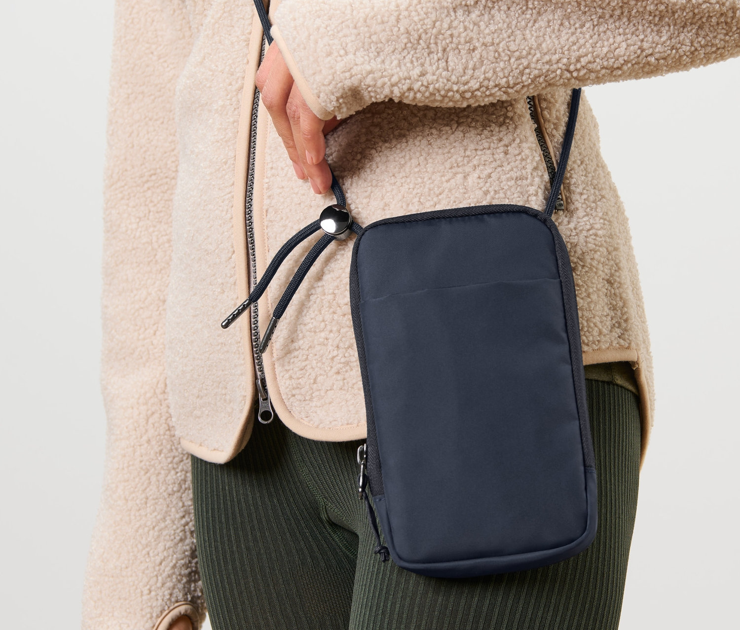 Frau trägt dunkelblaue Anti-Frost-Handytasche über der Schulter.