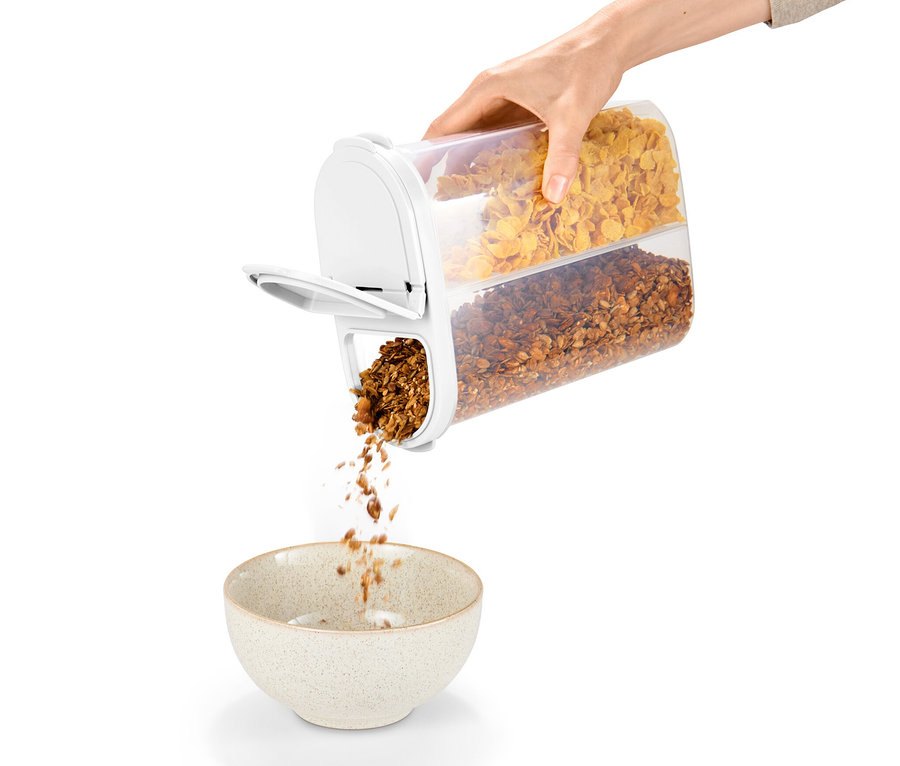 Eine Hand hält eine 2-in-1-Vorratsdose und schüttet Müsli in eine Schüssel.