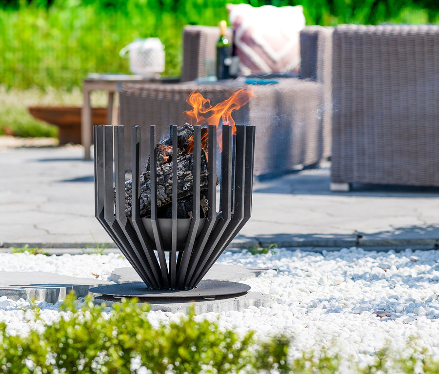 Aussenbereich mit Design-Feuerkorb Irving, im Hintergrund Gartenmöbel.