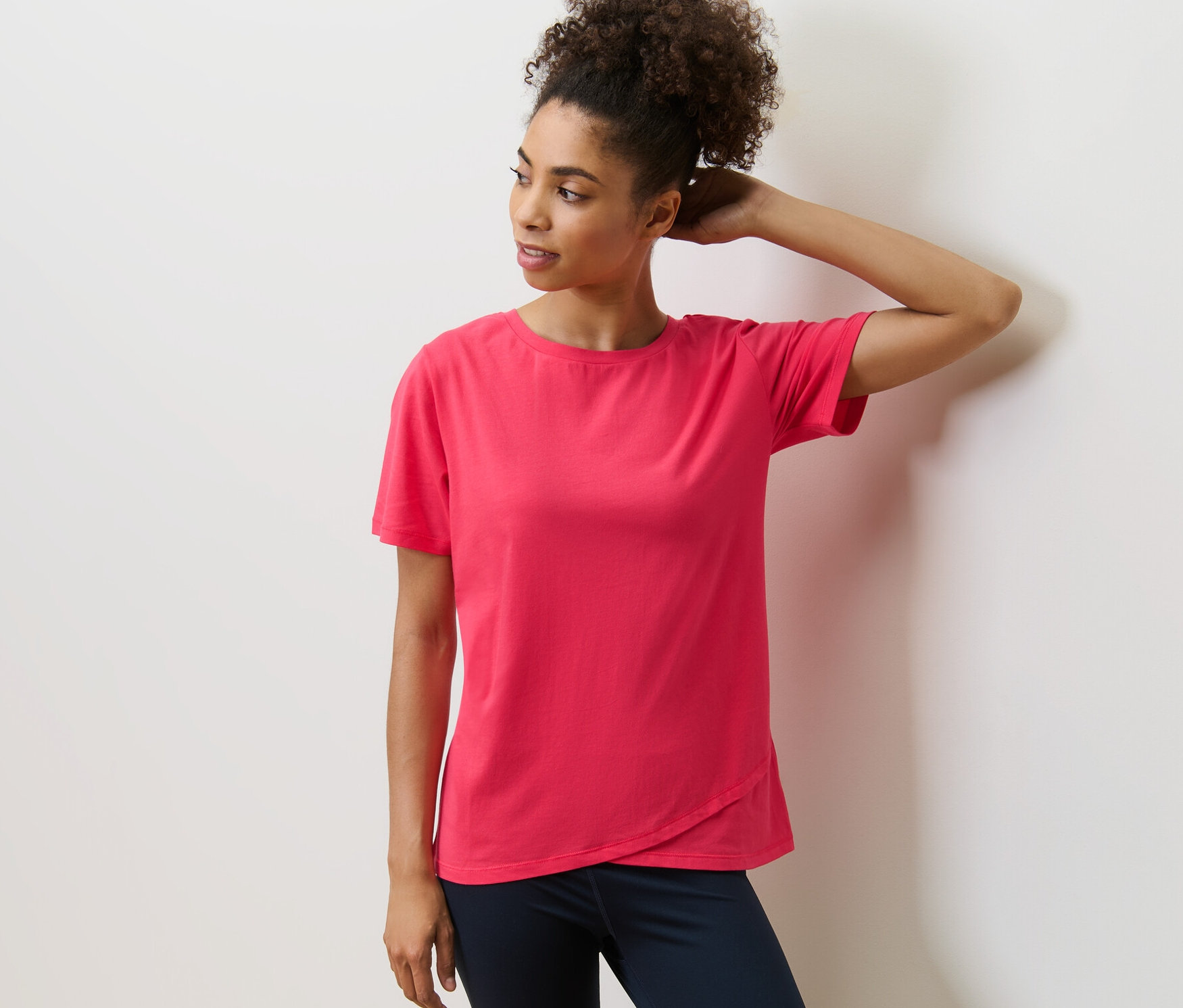 Frau posiert in einem Sportshirt.