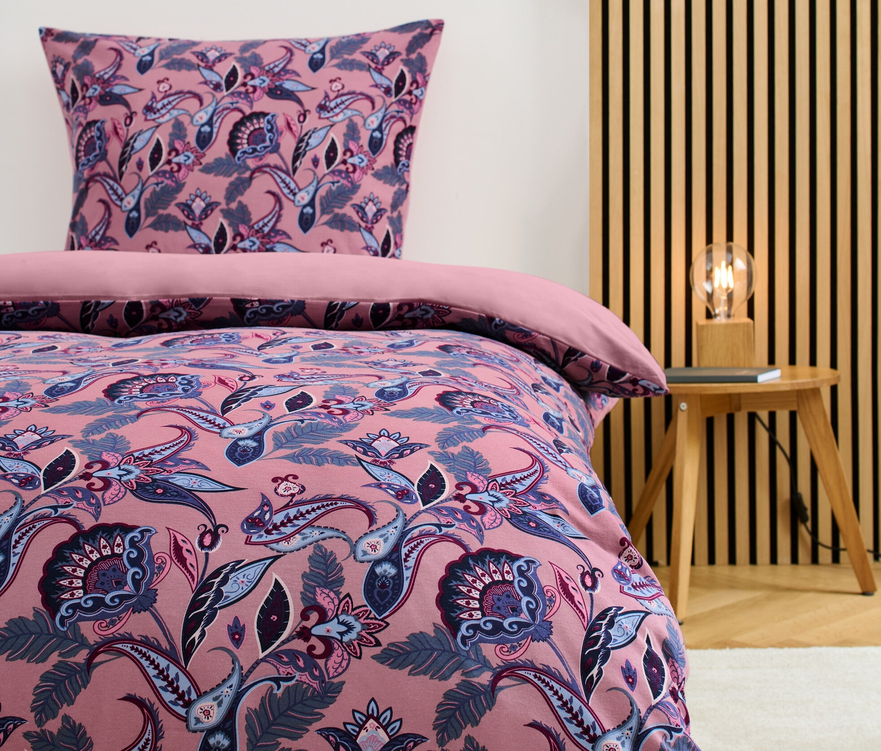 Winterjersey-Bettwäsche Normalgröße mit Blumenmuster auf einem Bett.