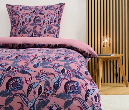 Winterjersey-Bettwäsche Normalgröße mit Blumenmuster auf einem Bett.