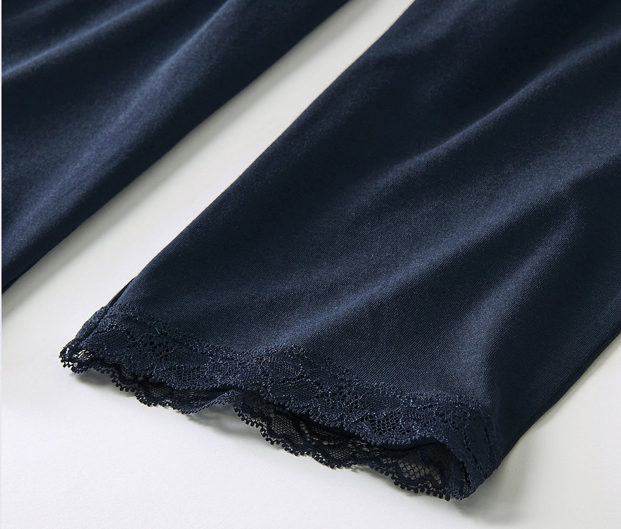 Detailansicht eines dunkelblauen Pyjamas mit Spitze.