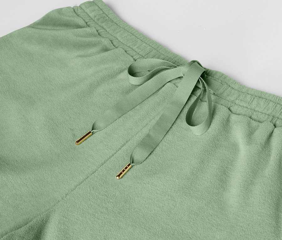 Detailaufnahme einer hellgrünen Jogginghose mit Kordelzug.