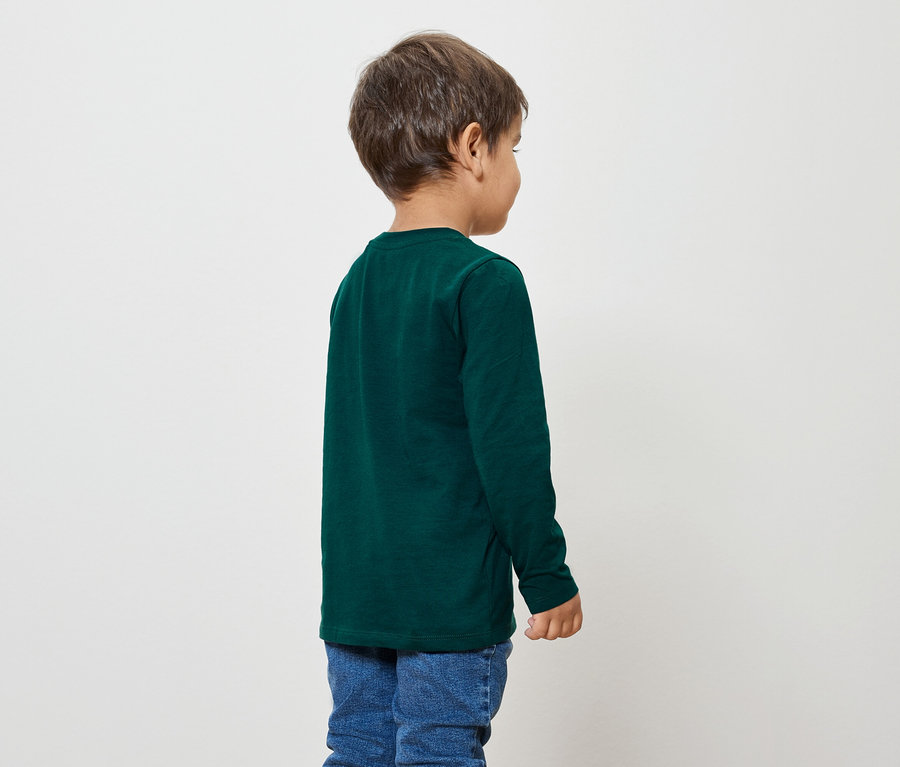 Junge mit dunkelgrünem Langarmshirt und blauen Jeans, von hinten aufgenommen.