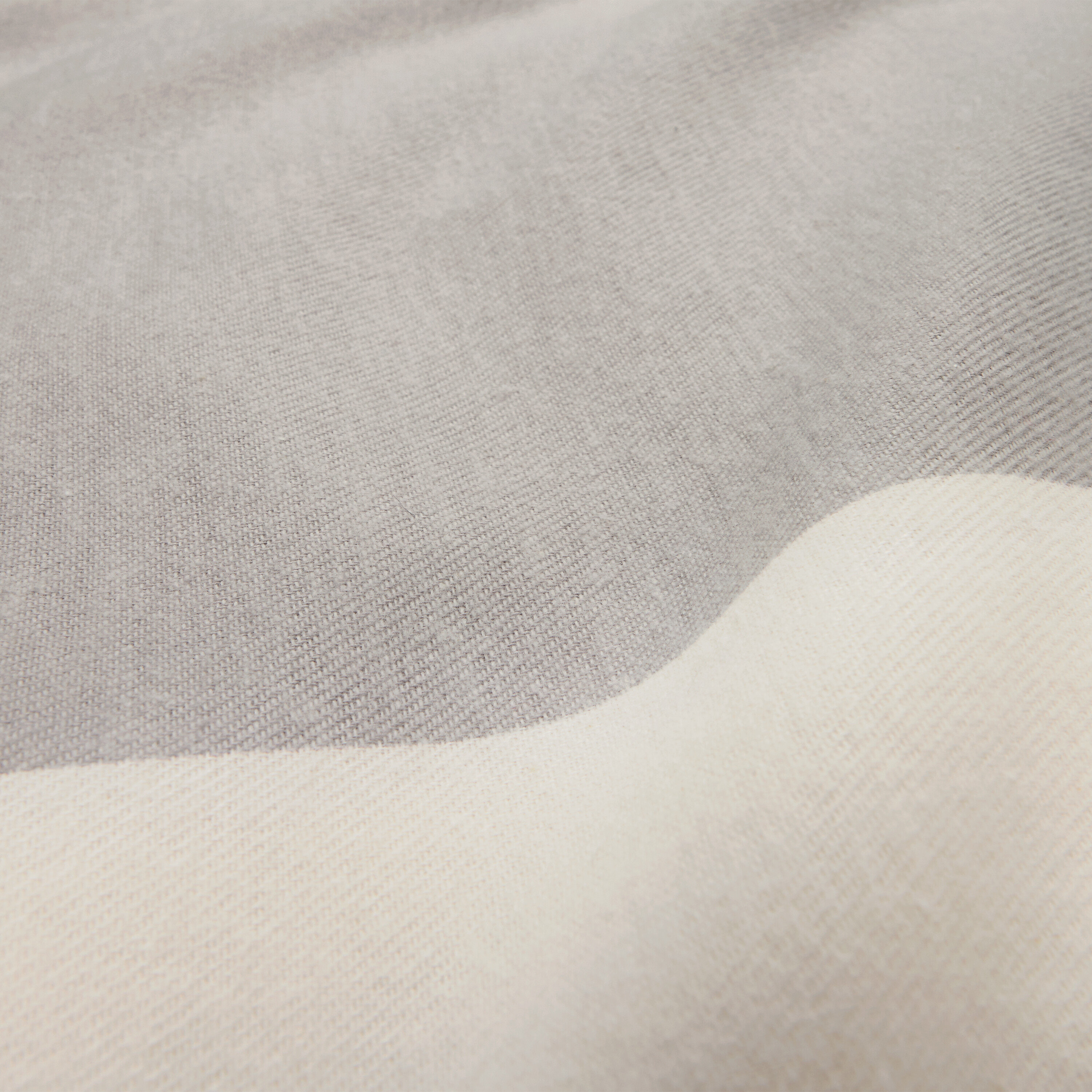 Detailaufnahme von Flanell-Bettwäsche in Normalgröße in Grau und Weiß.