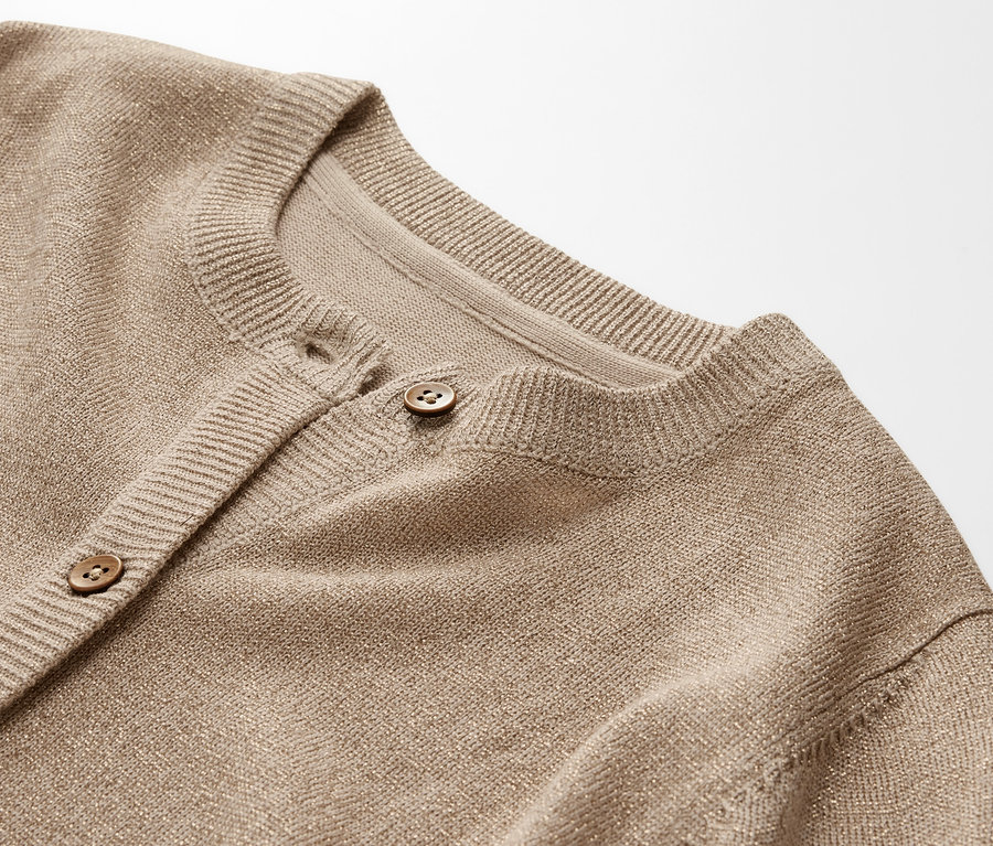 Detailansicht einer Kinder-Glitzerstrickjacke mit Knöpfen.