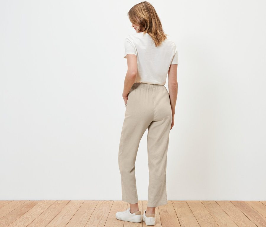 Frau von hinten in sandfarbener Leinenhose.
