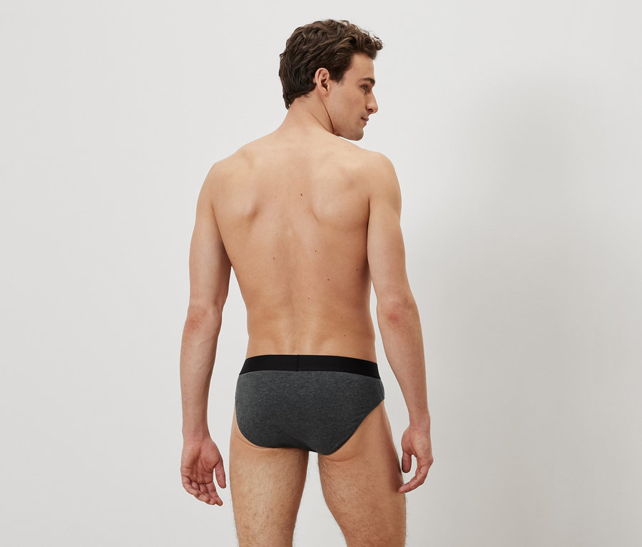 Ein Mann mit dem Rücken zur Kamera trägt graue Slips.