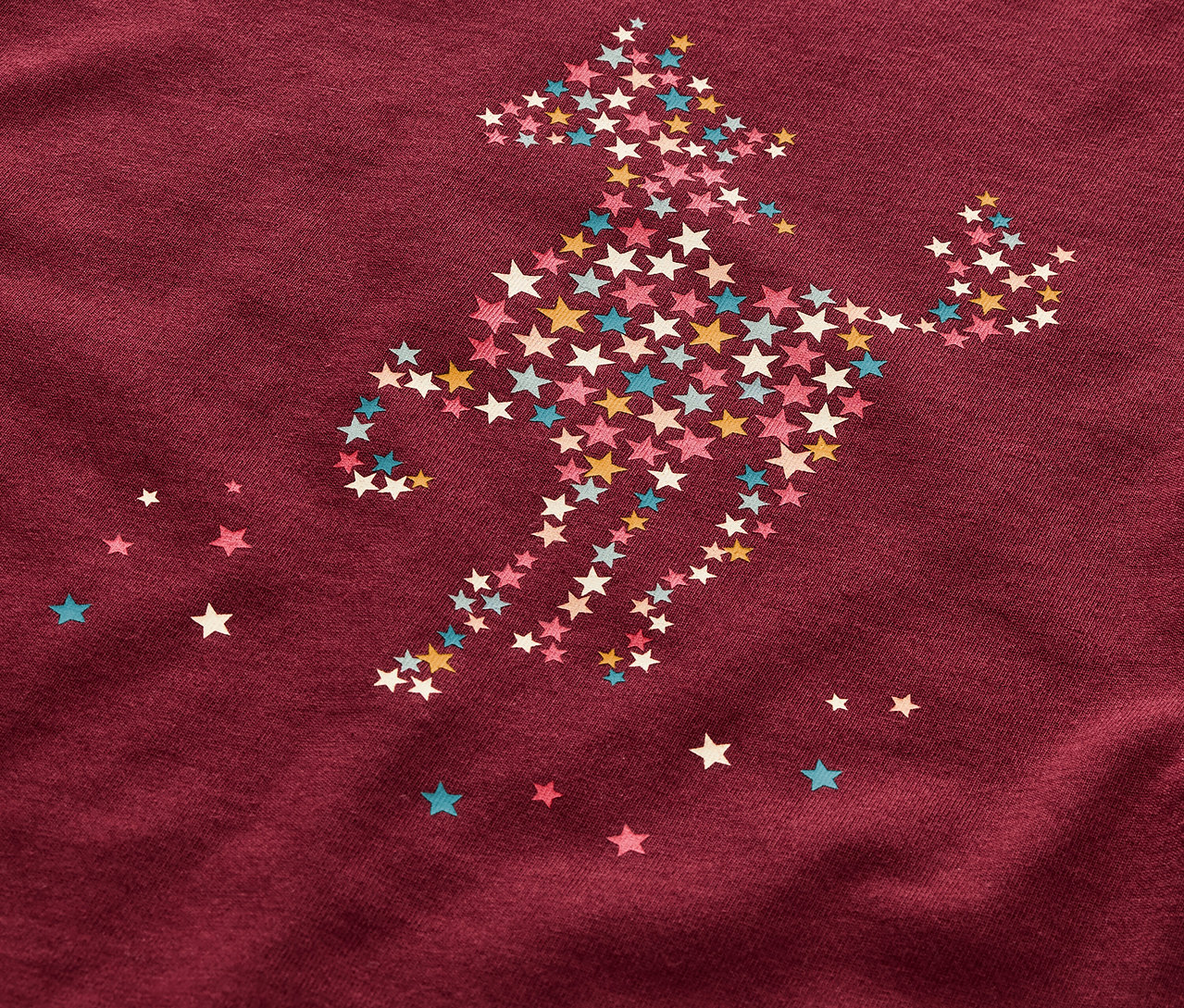 Detailaufnahme eines Kinderpyjamas mit einem Pferdemotiv aus Sternen.