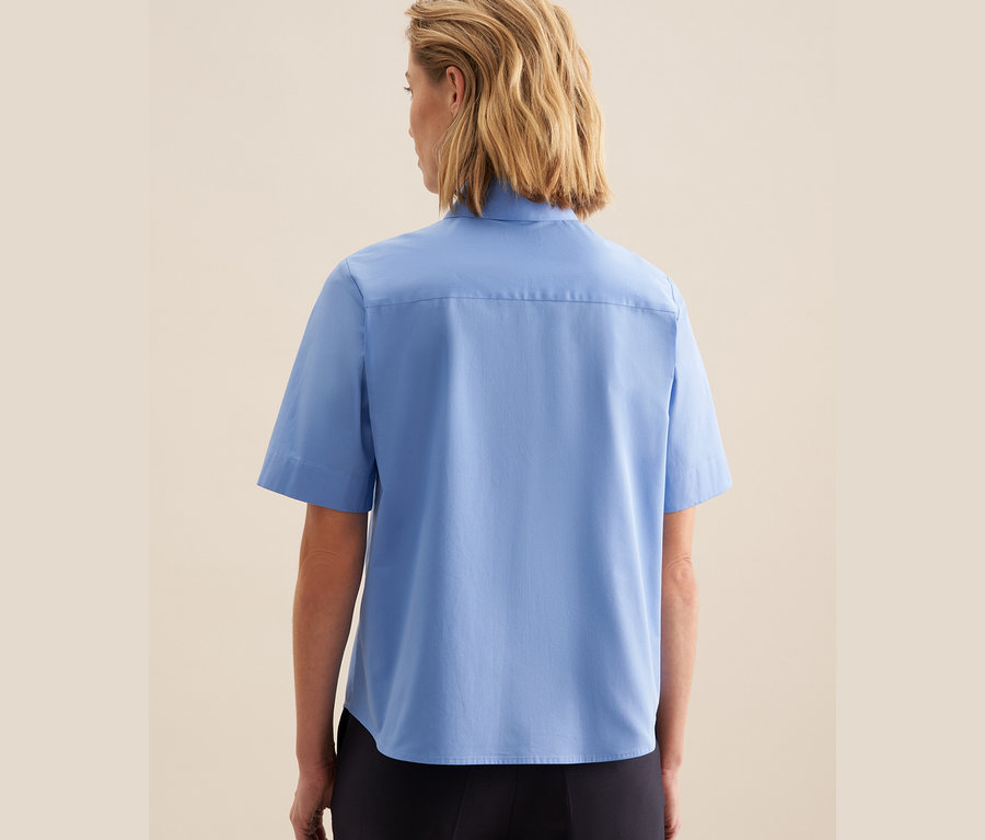 Frau trägt eine hellblaue Seidensticker Kurzarm-Bluse.