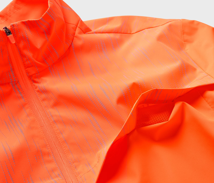 Detailaufnahme einer orangefarbenen Jacke mit Reißverschluss und Tasche.