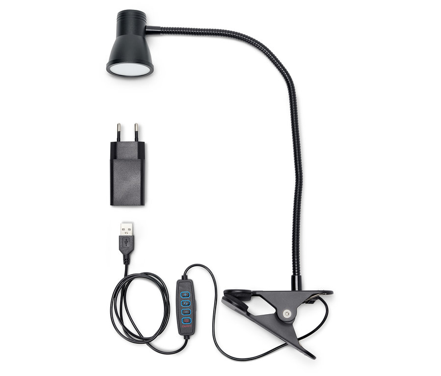 Eine schwarze LED-Klemmleuchte mit Adapter und USB-Kabel auf weißem Hintergrund.