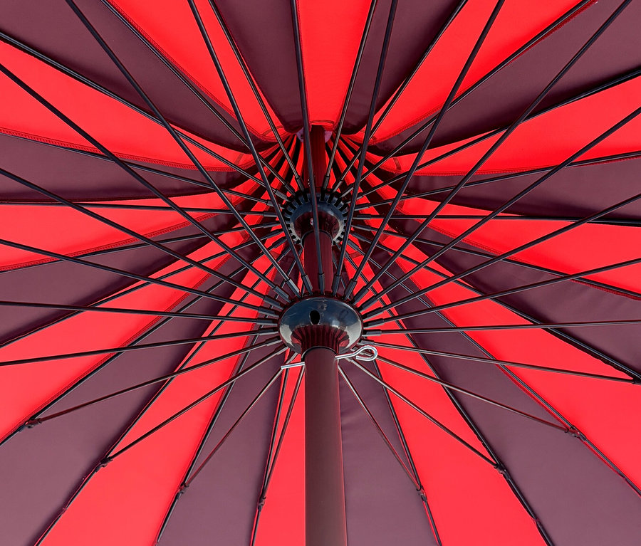 Ansicht von unten auf einen geöffneten Leco Sonnenschirm, Ø 240 cm, mit roten und braunen Segmenten.