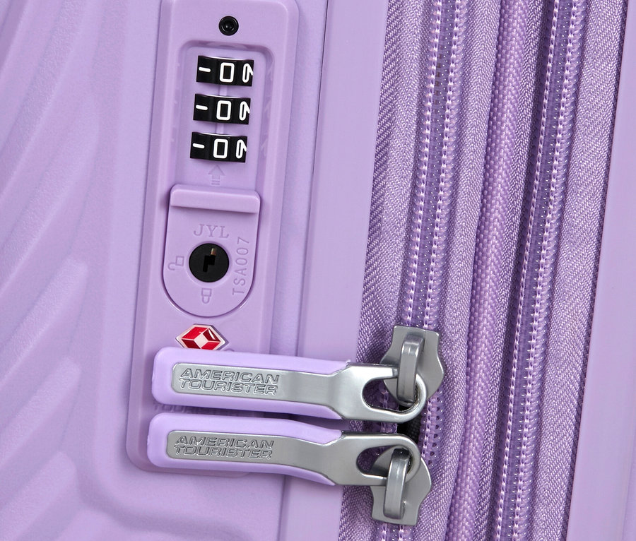 Nahaufnahme eines lilafarbenen American Tourister Koffers mit Zahlenschloss und Reißverschluss.