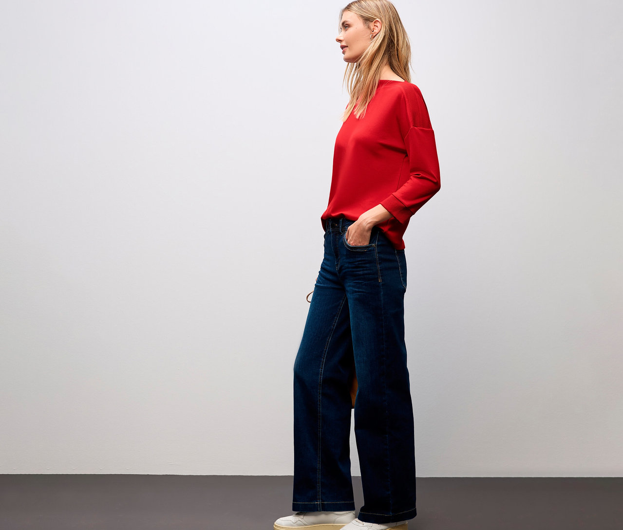 Frau mit rotem Street One T-Shirt mit Rippdetail und Bluejeans.