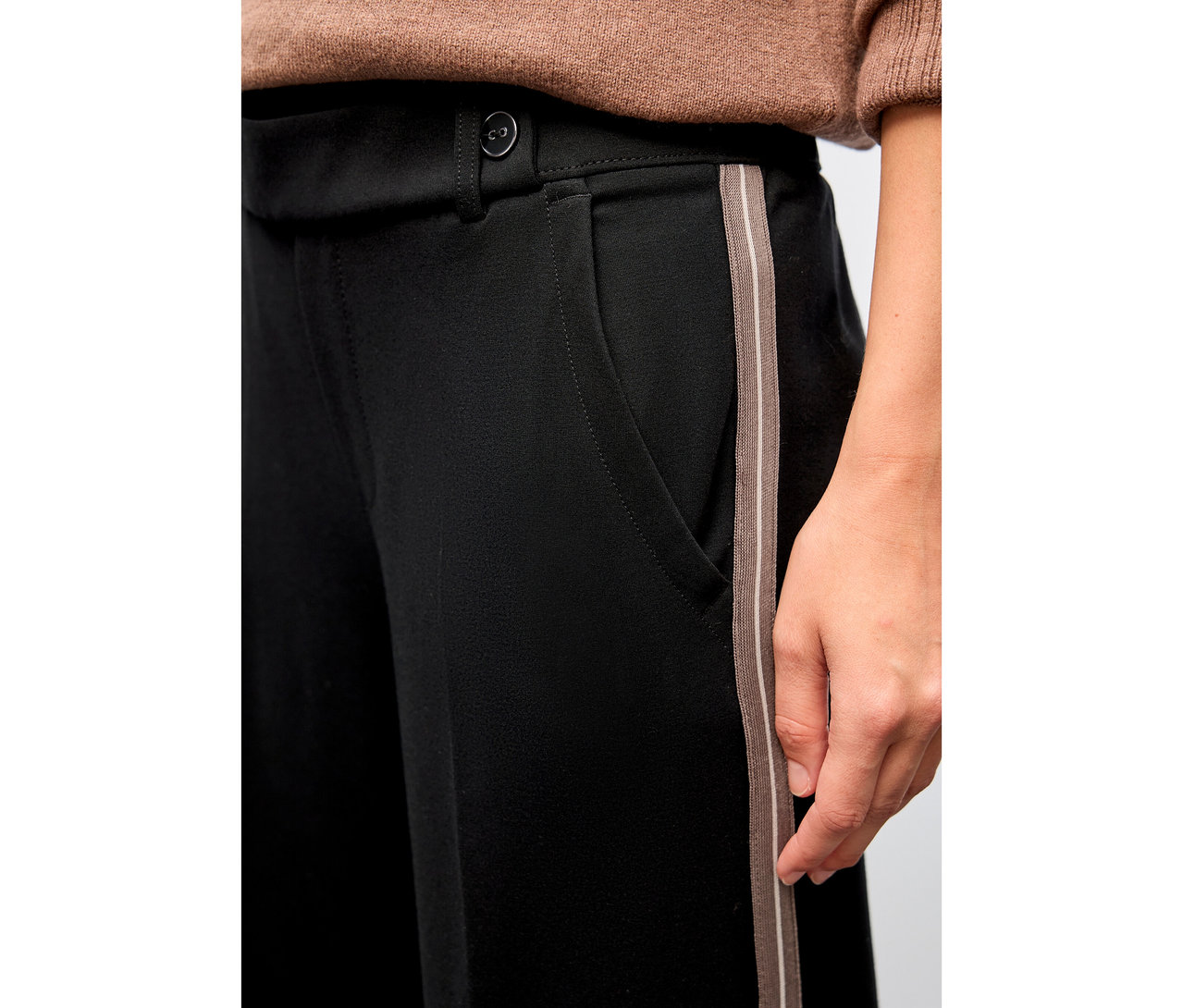 Nahaufnahme einer Person, die eine schwarze Street One Straight Leg Hose mit Gallonstreifen trägt.