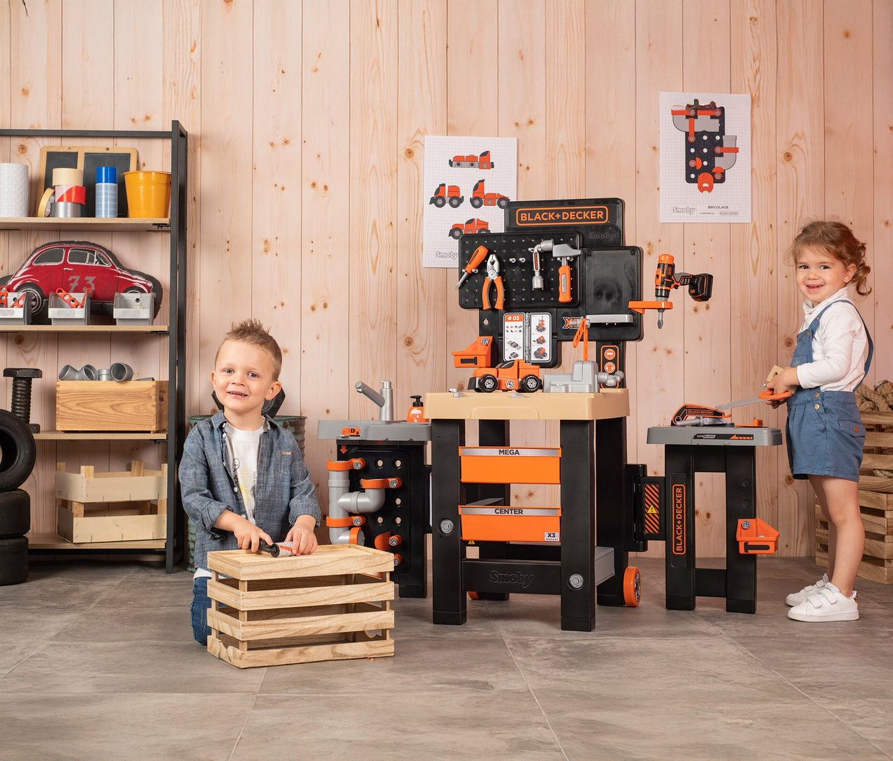 Zwei Kinder spielen mit einer Smoby »Black+Decker« Werkbank Mega Center, die mit Werkzeugen und Zubehör ausgestattet ist.