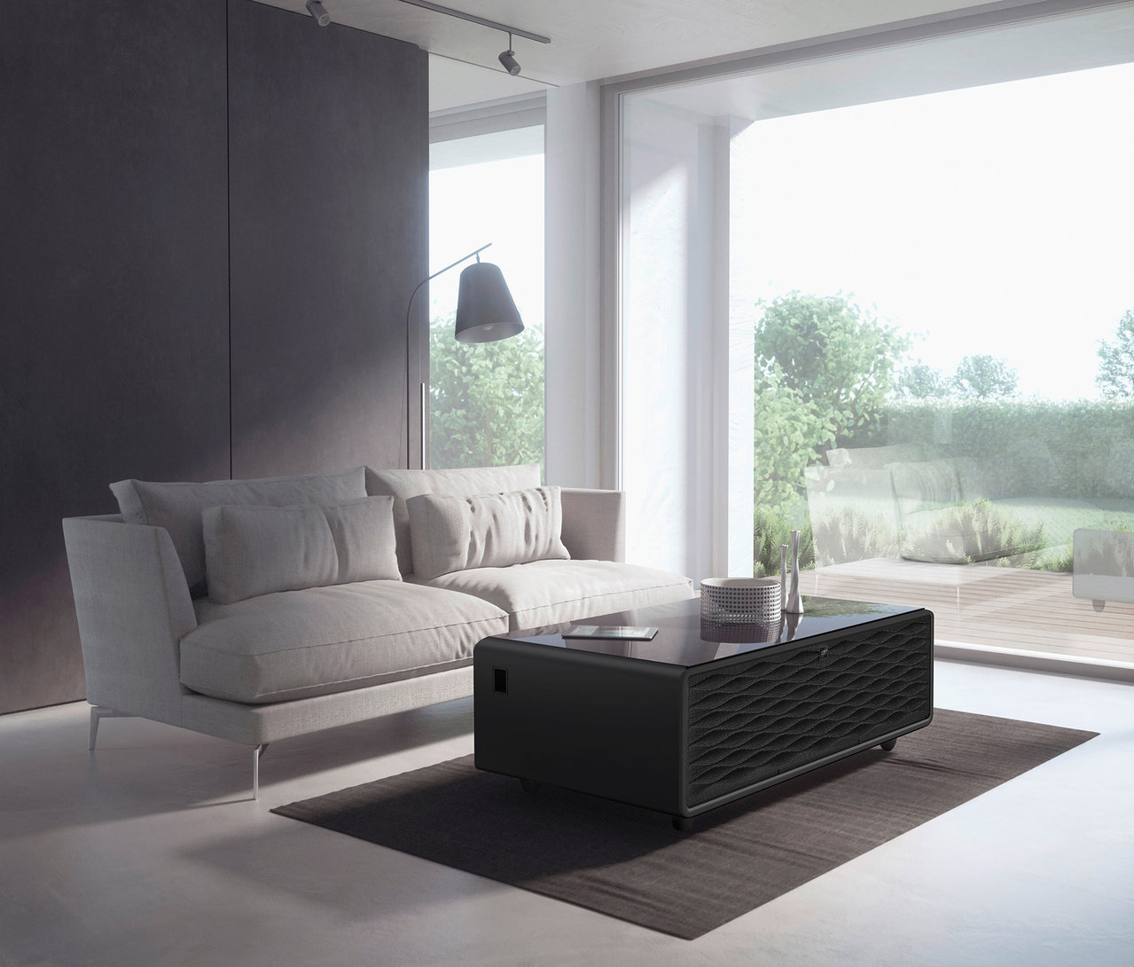 Wohnzimmer mit Sofa und schwarzem Caso Sound & Cool Tisch.