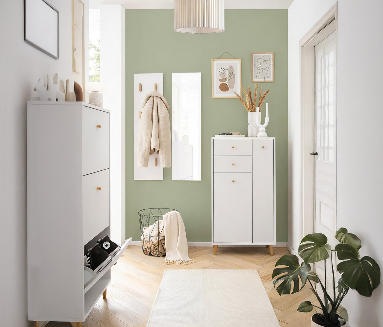 Flur mit weißem Schuhschrank, Garderobe und Kommode vor einer olivgrünen Wand.