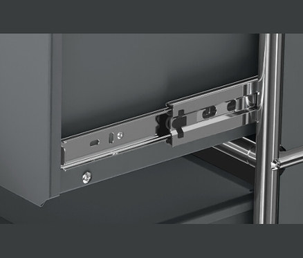 Detailansicht eines grauen CN3 Metallmöbels mit Schublade und Metallschienen.