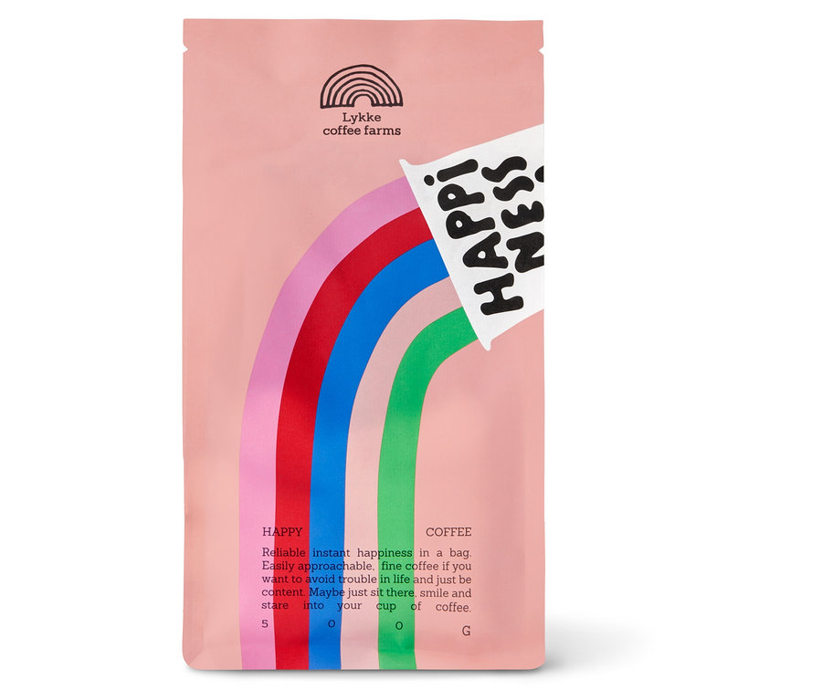 Eine hellrosa Kaffeepackung mit einem Regenbogenmuster in Rosa, Rot, Blau und Grün. Oben links ist das Logo „Lykke coffee farms“ und oben rechts der Schriftzug „HAPPINESS“ zu sehen.