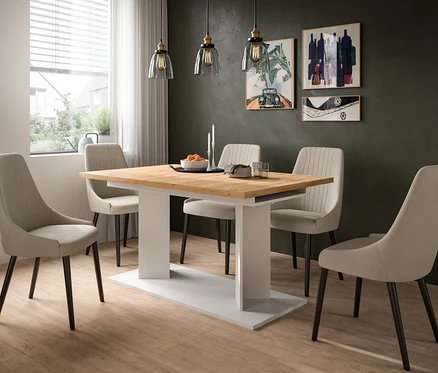 Ein modernes Esszimmer mit einem Holztisch und sechs beigefarbenen Polsterstühlen. Drei Pendelleuchten hängen über dem Tisch, der mit Obst und Kerzen dekoriert ist. Abstrakte Kunst ziert die dunkle Wand.