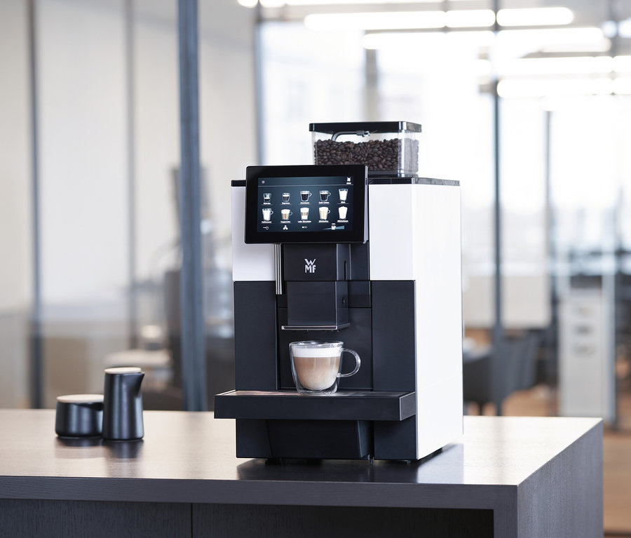 WMF 950 S Profi-Kaffeevollautomat mit Tasse Cappuccino auf einem Tisch.