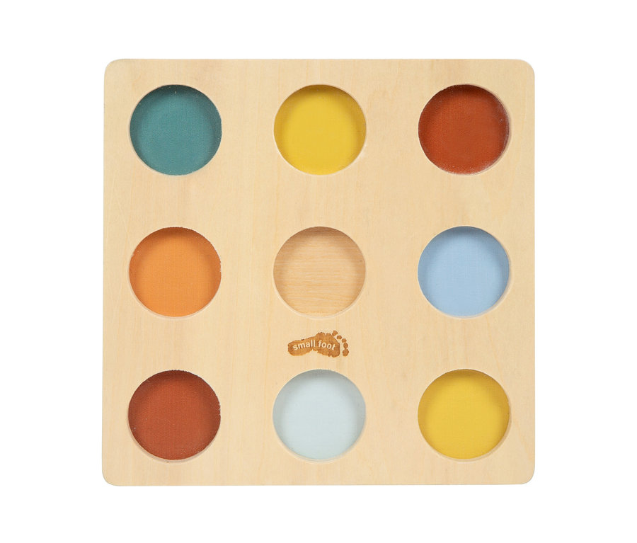 Quadratisches Holzbrett mit neun runden Löchern in einem 3x3-Raster. Die Löcher sind mit farbigen Einsätzen in Türkis, Gelb, Orange, Hellblau, Terrakotta und Hellgrau gefüllt. Das mittlere Loch ist leer, zeigt Holz und trägt ein „small foot“-Logo.