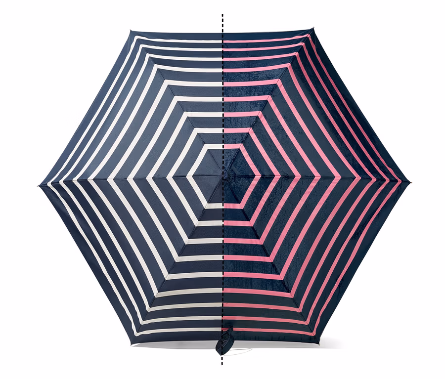 Detailansicht von oben eines geöffneten Regenschirms mit Farbwechsel und abwechselnd weißen und pinken Streifen auf marineblauem Hintergrund.