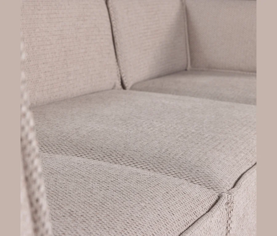 Nahaufnahme eines hellbeigen Sofas mit strukturiertem Stoffbezug und sichtbaren Sitz- und Rückenkissen.