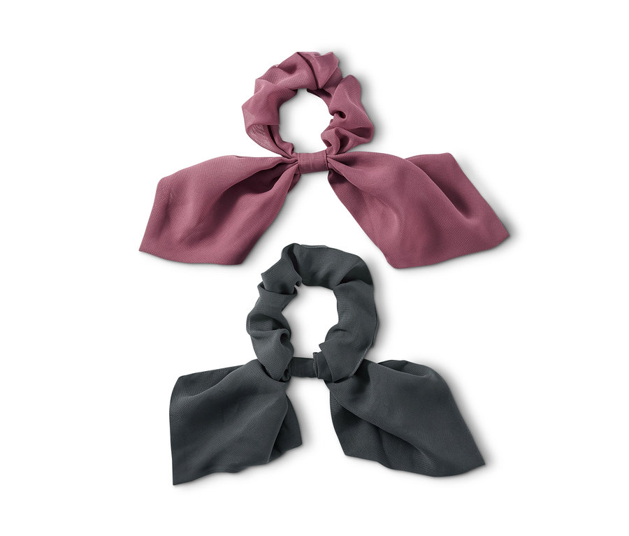 Zwei Haargummis »Scrunchies« mit Schleife liegen auf weißem Hintergrund.