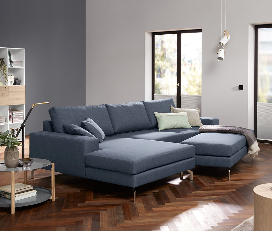 Blaues Ecksofa mit Glas-Couchtisch.