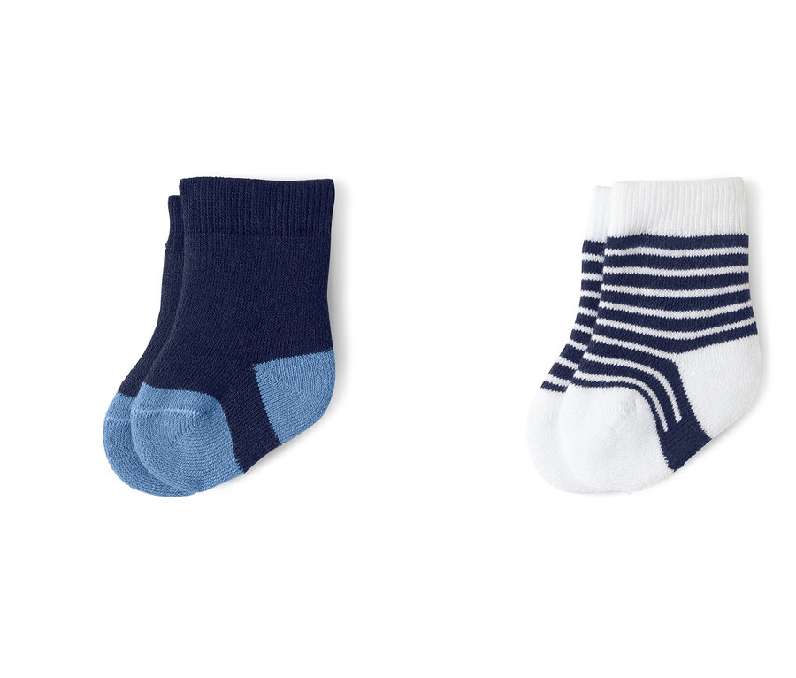 Drei Paar Babysocken: hellblaue mit Wal, dunkelblaue und weiße mit blauen Streifen.