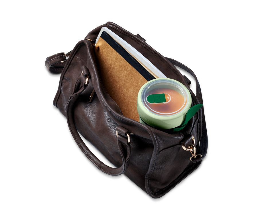 Braune Handtasche mit Suppenbehälter, Buch und Heften.