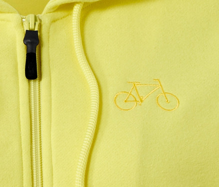 Detailansicht einer gelben Sweatjacke mit Kapuze und aufgesticktem Fahrrad.