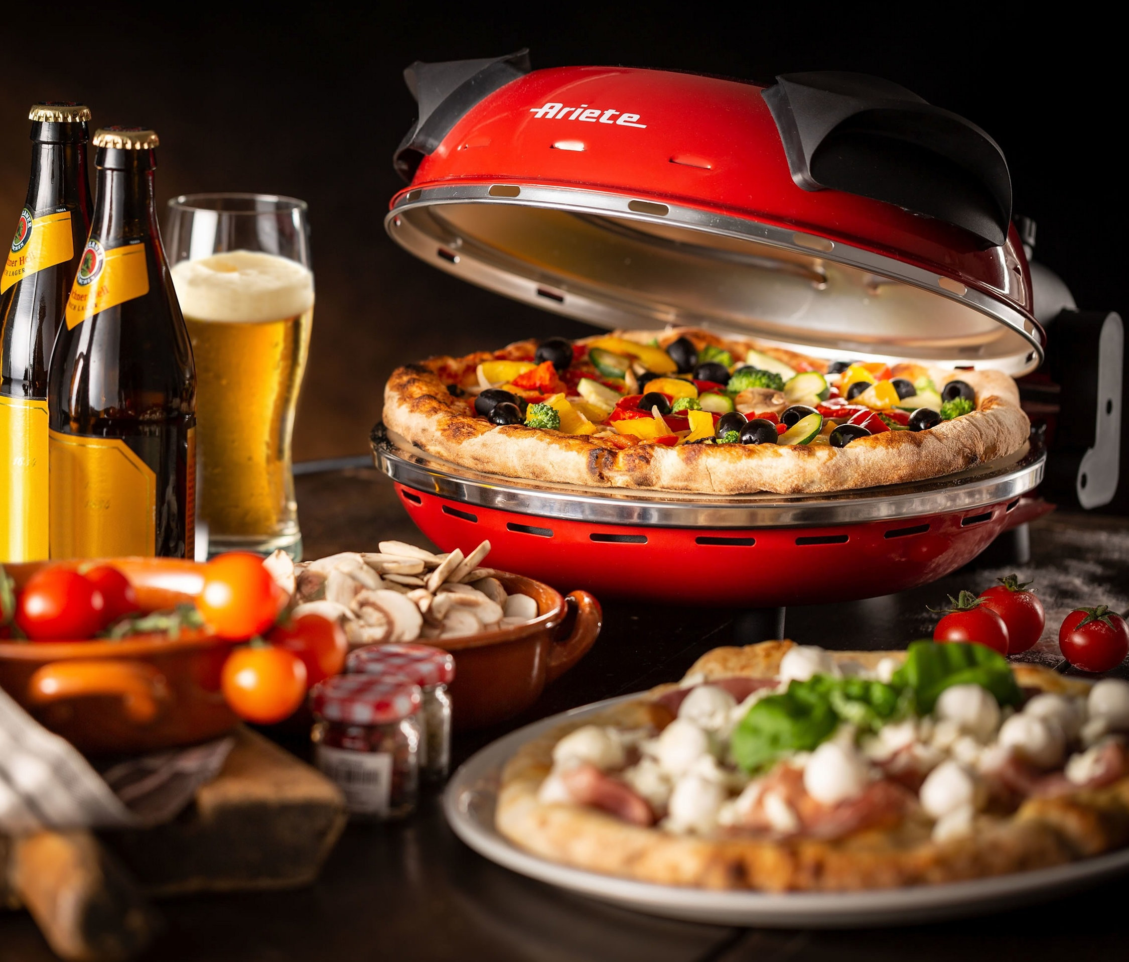 Pizza mit verschiedenen Zutaten im roten Ariete-Pizzaofen "909".