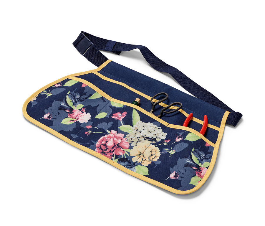Ein Gartenwerkzeug-Gürtel mit Blumenmuster und Werkzeugen in den Taschen.