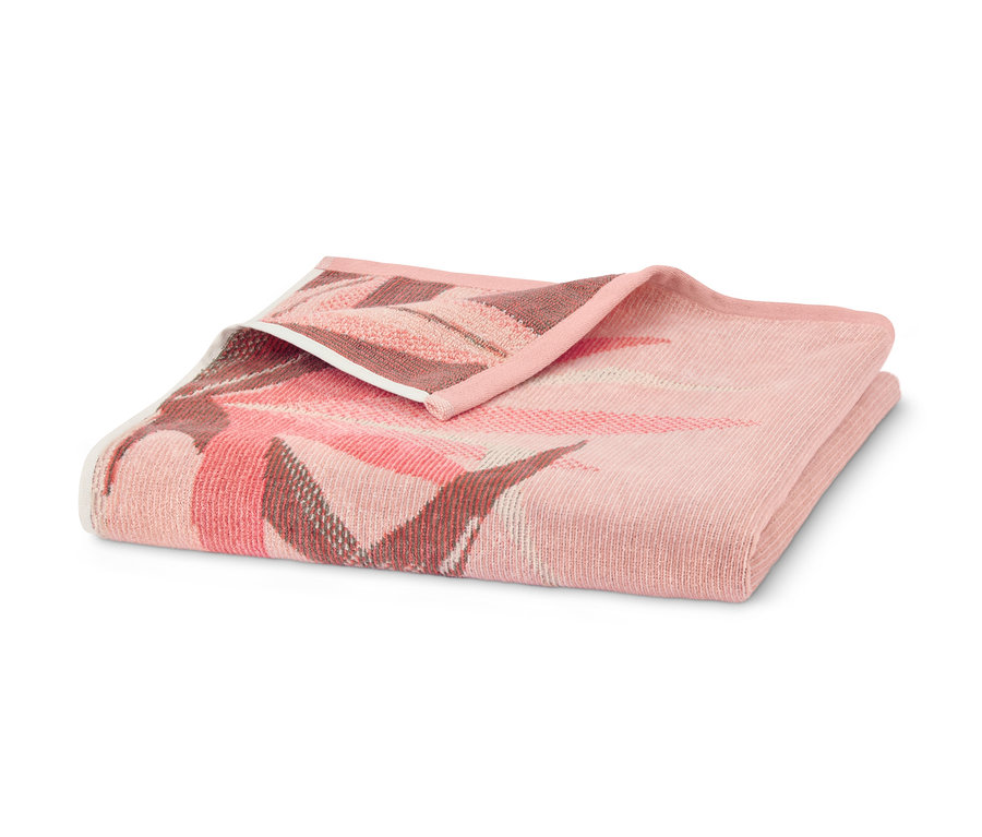 Ein apricotfarbenes Veloursbadetuch im Tropic-Design, gefaltet auf einem weißen Hintergrund.